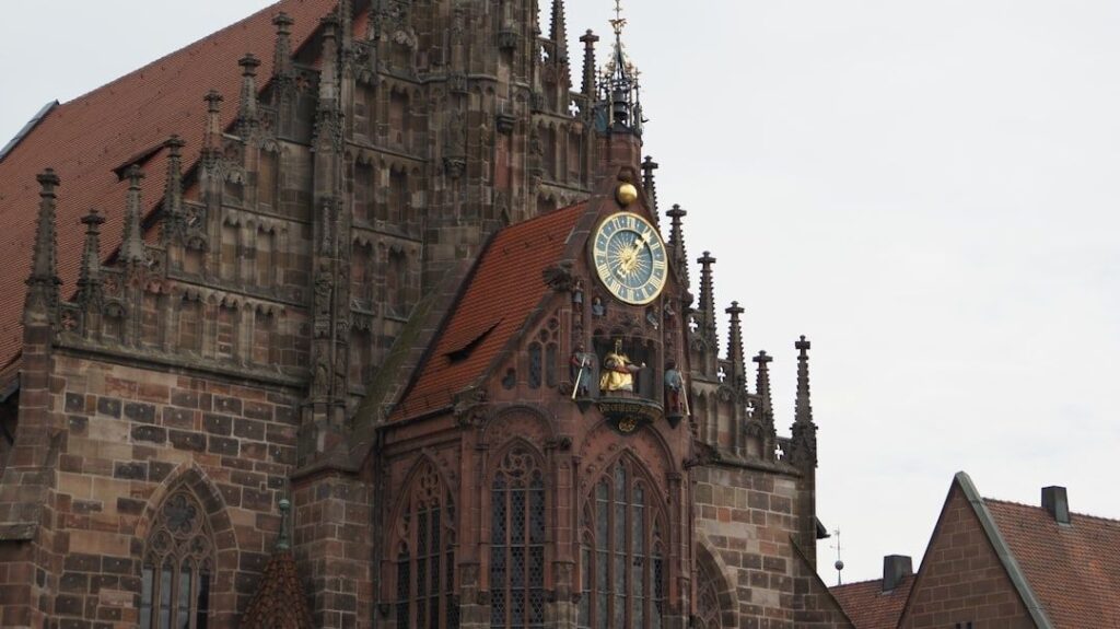 Historische Sandsteinfassade mit reich verziertem Erker und Uhr