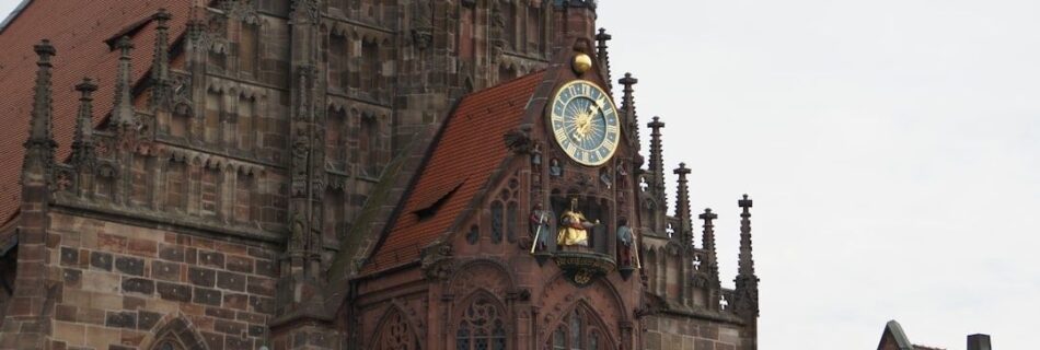 Historische Sandsteinfassade mit reich verziertem Erker und Uhr