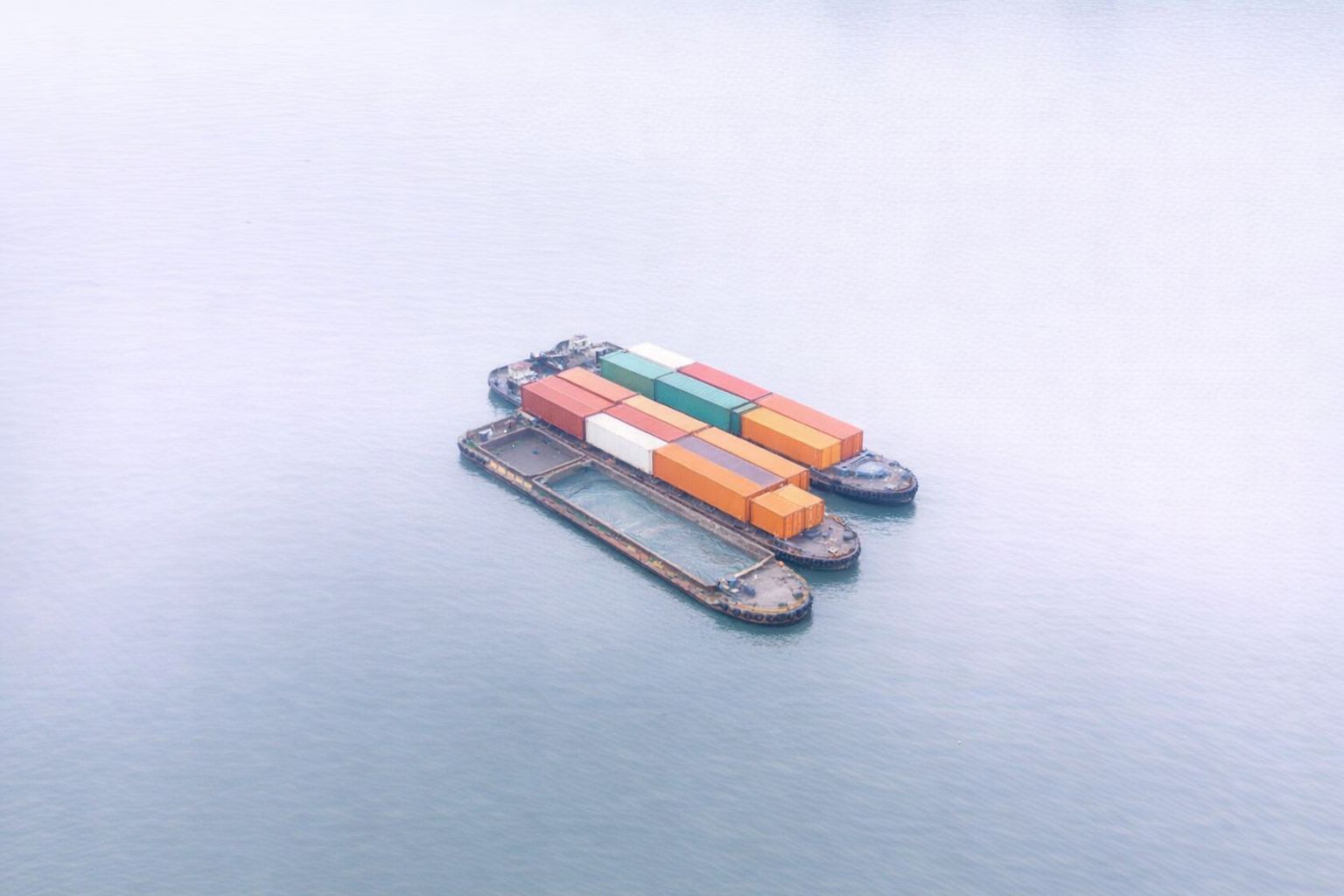 Binnenschiffe mit bunten Containern auf ruhigem Wasser für den Museumstransport.